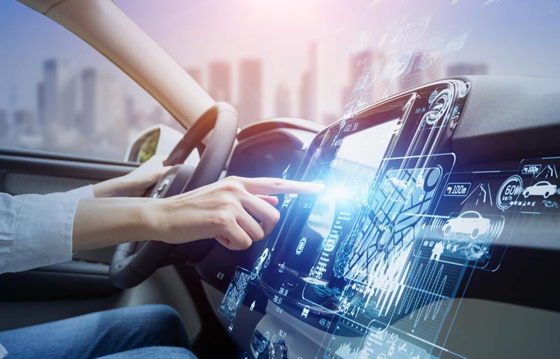 Person sitzt in Auto tippt auf hochmodernen Bildschirm